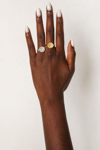 close-up-image-of-a-hand-with-painted-nails-wearing-gold-rings-including-that-of-the-spell-s-stargazer-zodiac-ring