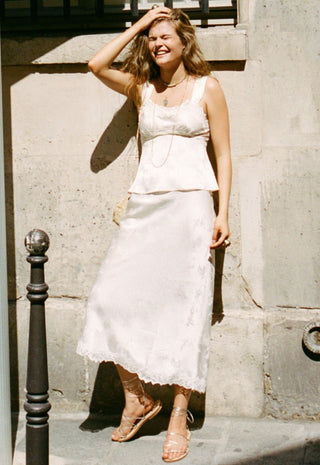  with a small beige shoulder bag and tan strappy sandals.